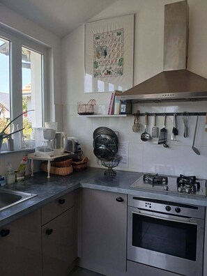 A kitchen with a stove, oven, and various utensils. - Chat Fleurs" family home Pornichet center very quiet (Pornichet)