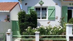 Un bâtiment avec une enseigne indiquant « Chats Flowers » et une clôture verte.