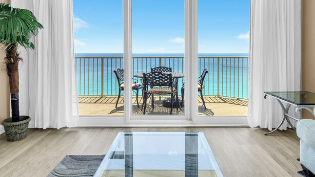 Ein Zimmer mit Glastür und Zugang zu einem Balkon mit Meerblick.