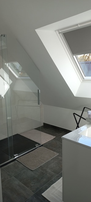 A modern bathroom with a glass shower enclosure, a skylight, and a white countertop. - New 2-person apartment near the sea (CLOHARS CARNOET)