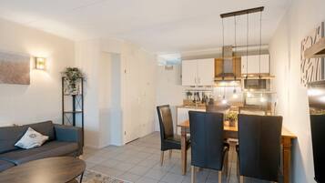 Un salon moderne comprenant un canapé, une table basse et un coin repas avec des chaises et une table.