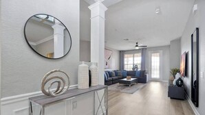 Un salon moderne avec un canapé, une table basse et des objets décoratifs disposés sur une console.