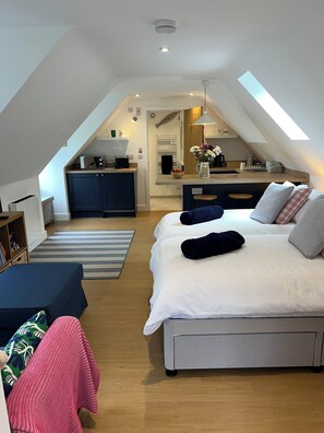 Een moderne loft slaapkamer met een groot bed, een kitchenette en een eethoek.