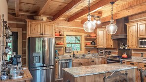 A spacious kitchen with wooden cabinets, stainless steel appliances, and a granite countertop.
