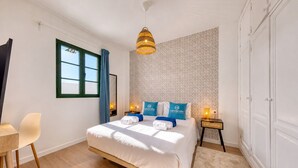 Ein Hotelzimmer mit Bett, Schreibtisch, Stuhl, Fenster und Kleiderschrank.