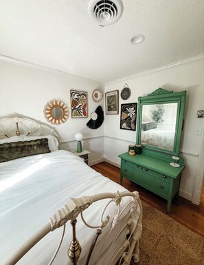 A bedroom with a bed, dresser, and wall decorations. - The Joyful Escape | Playful 70s-Modern Retreat (Crewe)
