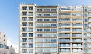 A multi-story residential building with balconies, large windows, and a clear sky. - Lavistamare - wake up with a sea view (Westende)