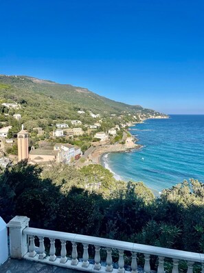 A coastal town with buildings, a clear blue sea, and a hilly backdrop. - Villa debut Cap Corse 5mn D'ERBALONGA (BRANDO)