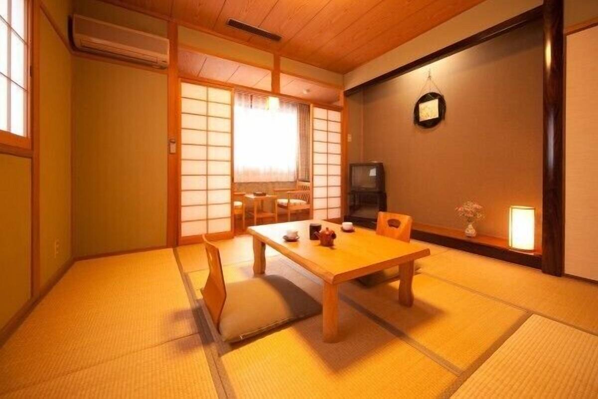 A traditional Japanese room with tatami flooring, a low table, and sliding doors.
