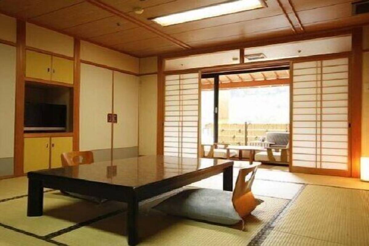 A traditional Japanese room with tatami flooring, a low table, and sliding doors.