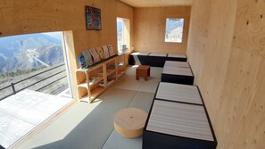 Un interior de madera con esteras de tatami, una estantería y un banco.