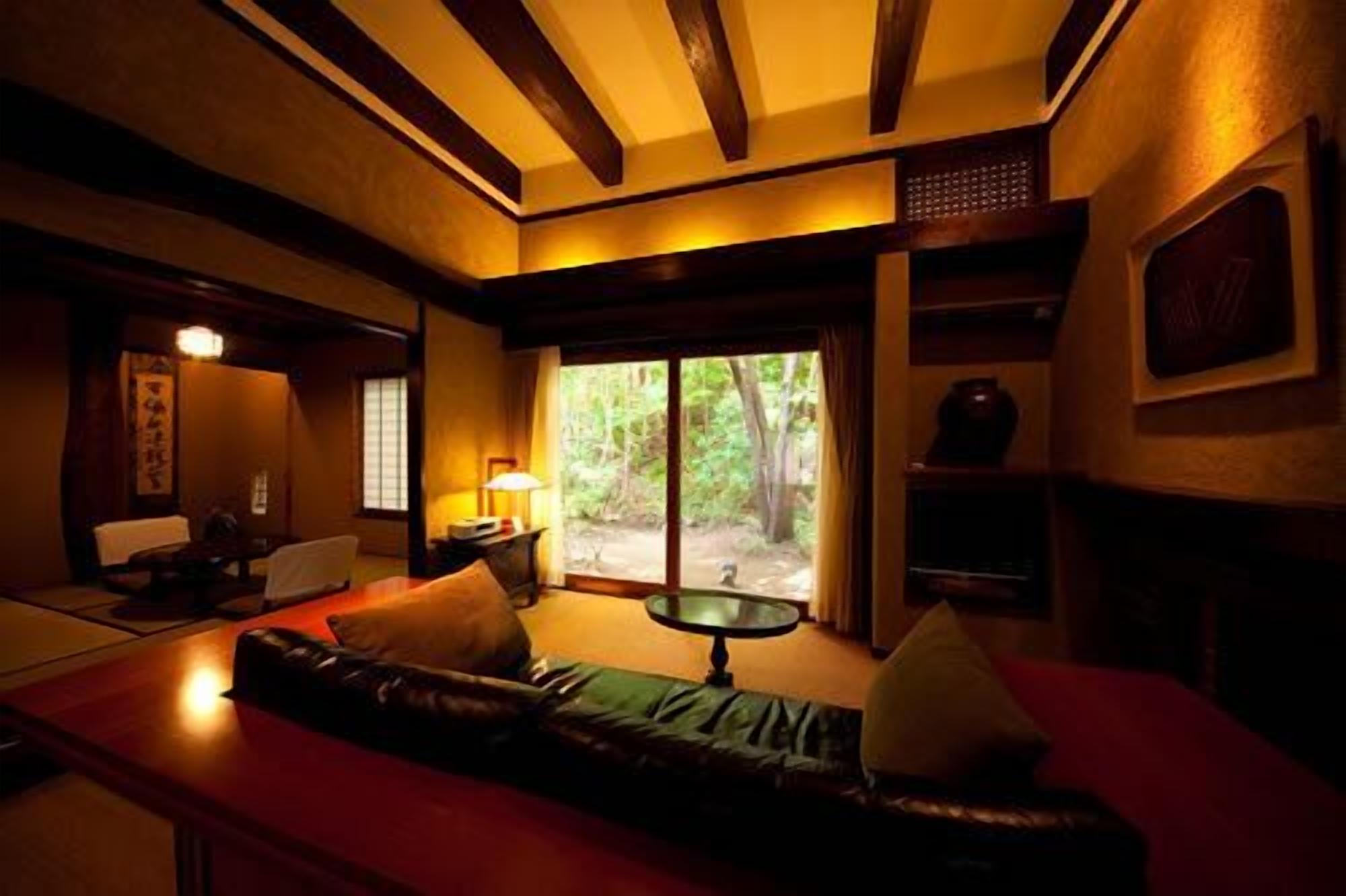Una habitación con techo de madera, un sofá, una mesa y vistas al exterior.