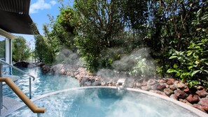 A hot spring surrounded by rocks and lush greenery. - Yaizu Grand Hotel (Yaizu)