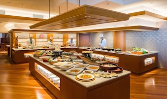 Montaje tipo buffet con varias estaciones de comida y chefs atendiendo.