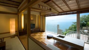 A modern room with a checkered floor, a television, a sofa, and a view of the sea.