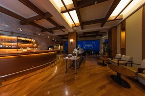 A bar area with a wooden counter and seating arrangement in the background. - Yaizu Grand Hotel (Yaizu)