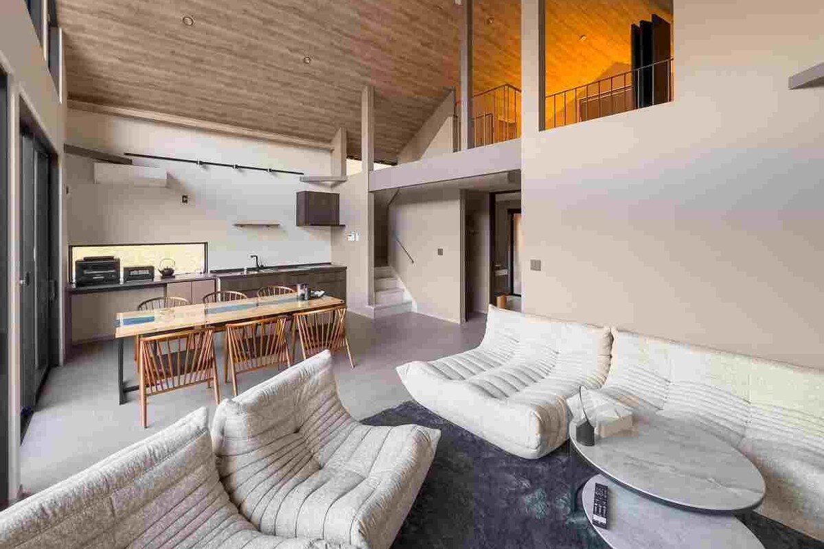 Ein modernes Interieur mit Essbereich, Sofas und einer Küche.