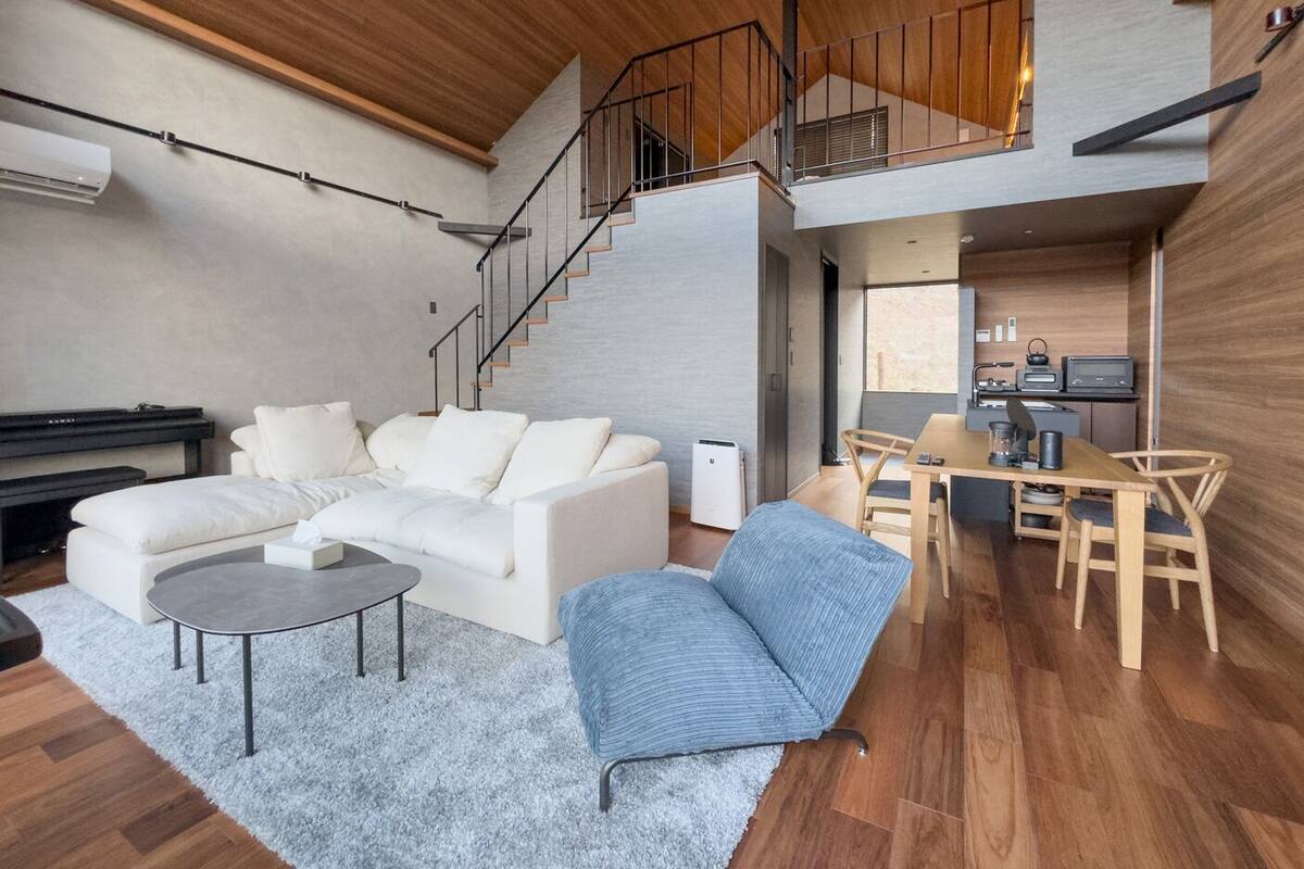 Un salon moderne comprenant un canapé, une table basse et un coin repas avec des chaises et une table.