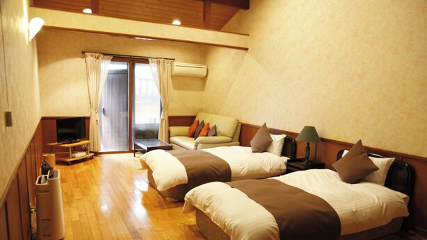 A hotel room with two beds, a sofa, a TV, and an air conditioning unit. - Hirayama Onsen Okuyamaga Onsen Ryokan (Yamaga)