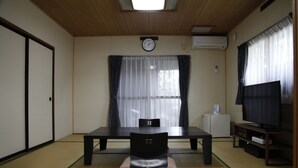 A room with tatami flooring, a low table, a chair, a television, and a clock on the wall. - Hirayama Onsen Okuyamaga Onsen Ryokan (Yamaga)