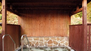 A wooden structure with a stone-tiled hot tub. - Hirayama Onsen Okuyamaga Onsen Ryokan (Yamaga)