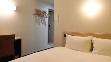 Una habitación de hotel con cama, escritorio y aire acondicionado.