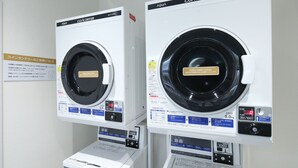 Deux machines à laver à chargement frontal, dotées de panneaux de commande, d’une étiquette indiquant le prix et d’une étiquette d’avertissement.