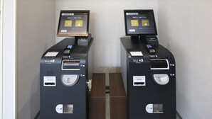 Deux bornes en libre-service équipées de lecteurs de cartes, d’un écran numérique et d’un distributeur de billets.