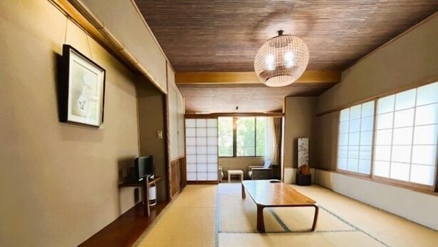 Ett traditionellt japanskt rum med tatamimattor på golvet, ett lågt trätak och skjutbara shojidörrar.