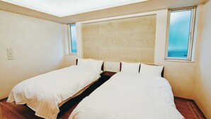 Una habitación con dos camas, un tragaluz y vistas al cielo.