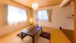 A traditional Japanese room with tatami flooring, a low wooden table, and sliding doors. - Ma Maison Mt. Fuji Kawaguchiko (Fujikawaguchiko)