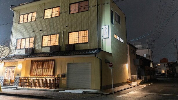 A multi-story building with a garage door, a 'No Entry' sign, and a 'No Parking' sign.
