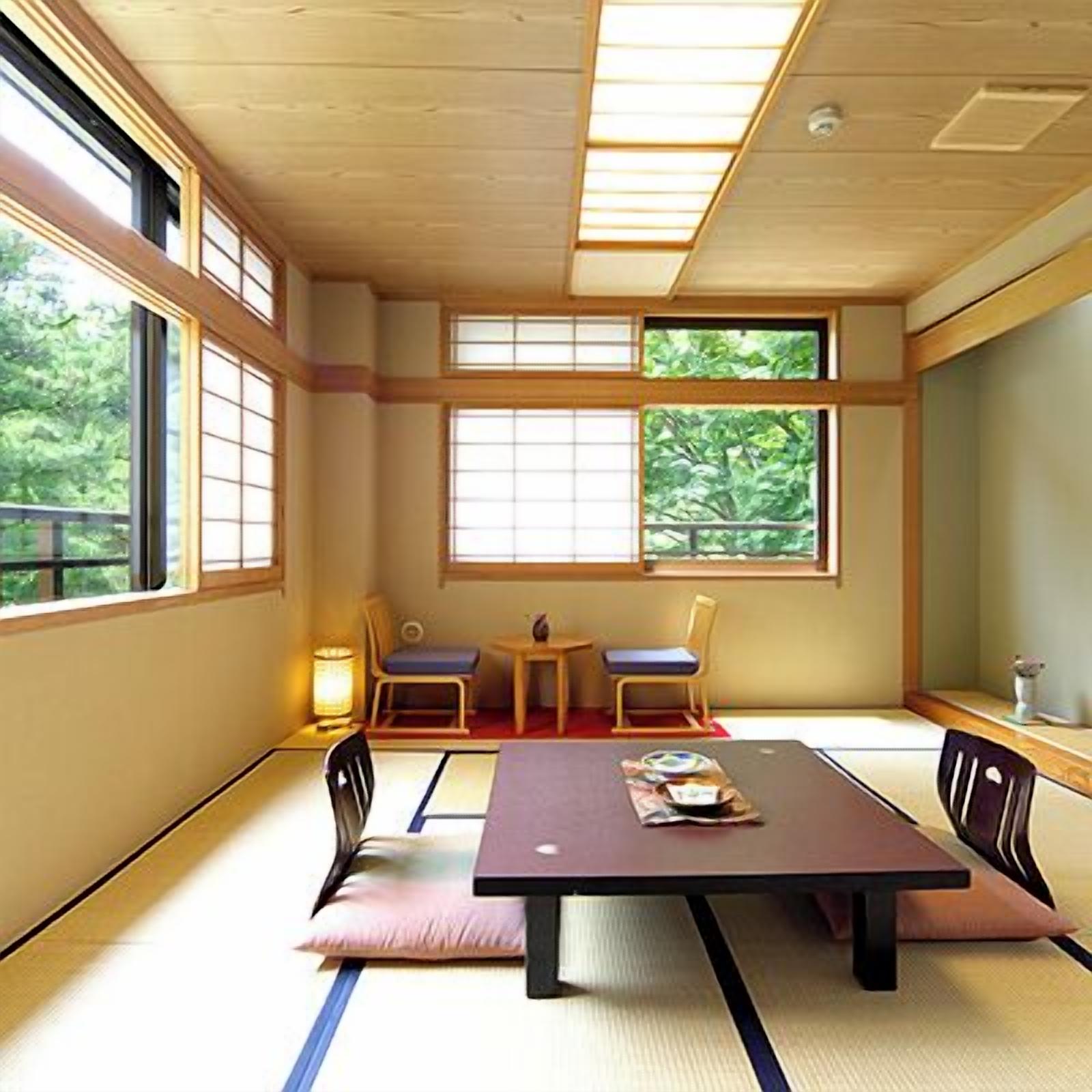 Una habitación tradicional con esteras tatami, una mesa baja, dos sillas y una mesita con una lámpara.