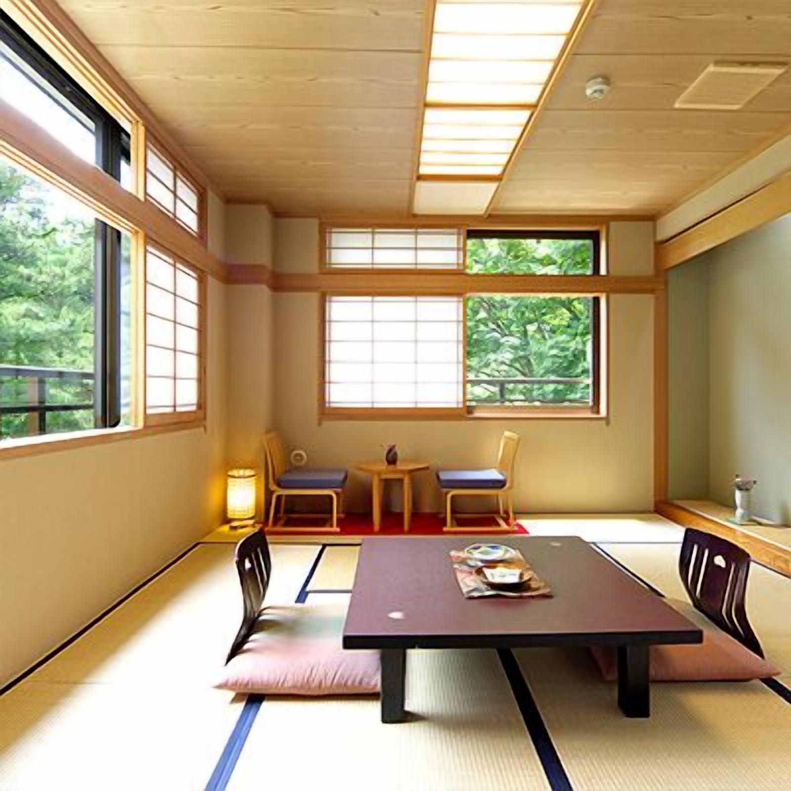 Una habitación tradicional japonesa con suelo de tatami, una mesa baja, dos sillas y ventanas grandes.