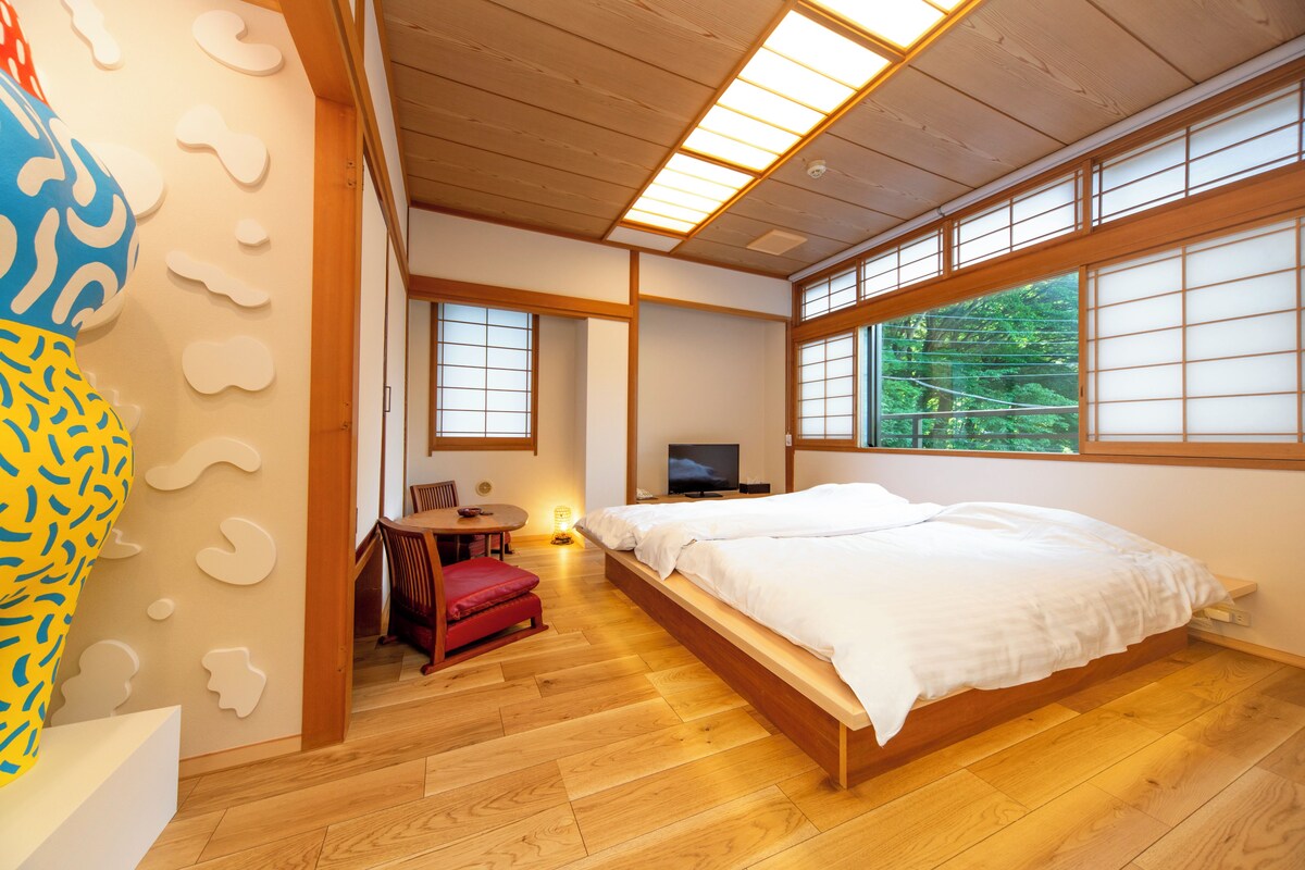 Une chambre avec un lit, un bureau, une chaise et un téléviseur.
