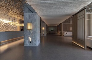 A modern lobby with a reception desk, a stone pillar, a white sofa, and a patterned ceiling. - Hotel Yukari-no-mori Kawaguchiko (Fujikawaguchiko)