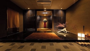 A modern interior with a checkered floor, a central pathway, and a decorative plant arrangement. - Nagomi Tsuki (Beppu)