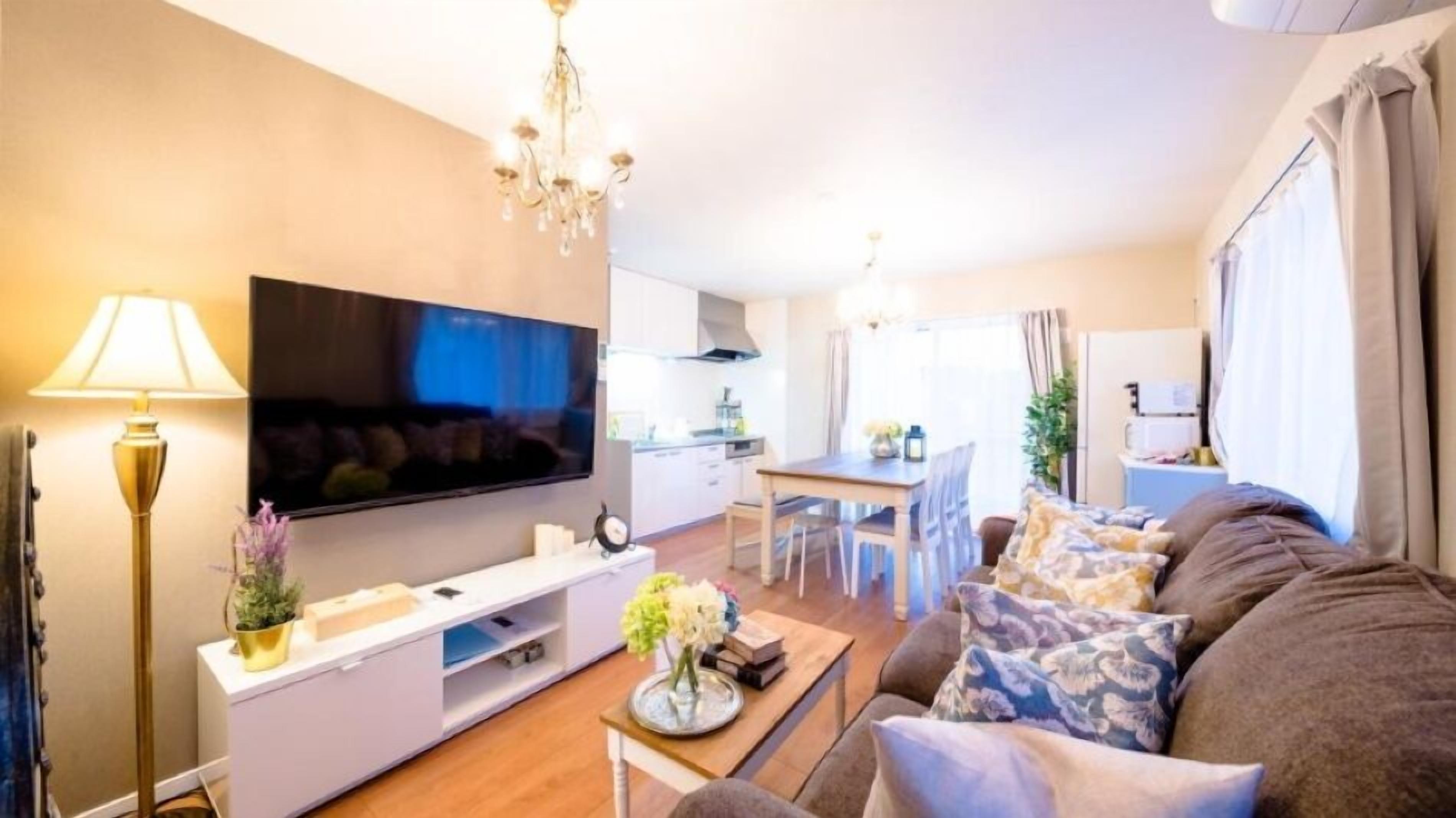 Ein modernes Wohnzimmer mit Flachbildfernseher, Esstisch und Sofa.