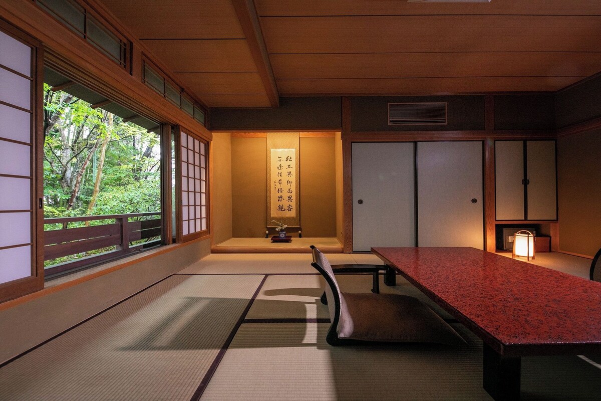 Ein traditioneller japanischer Raum mit Tatami-Böden, einem niedrigen Tisch und Schiebetüren.