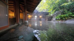 A traditional Japanese onsen with stone steps leading into a hot spring, surrounded by wooden architecture and greenery. - Yufuin Onsen Hinoharu Ryokan (Yufu)