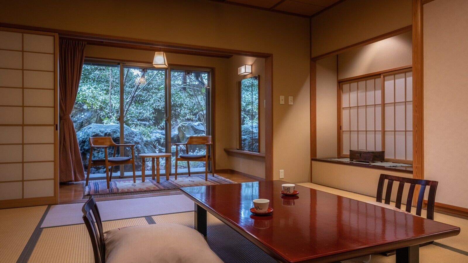 A traditional Japanese room with tatami flooring, a low table, and sliding doors.