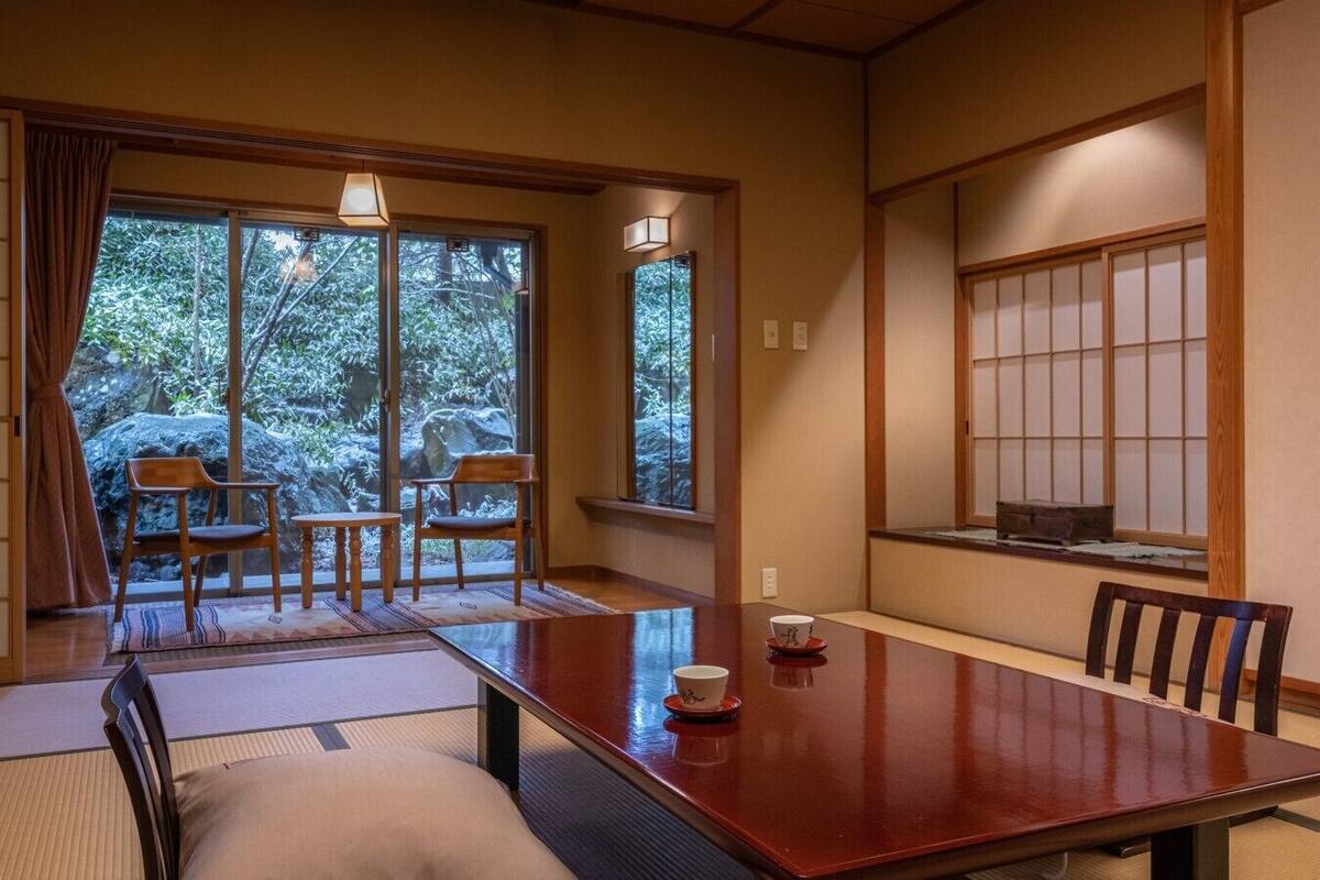 Ein traditioneller japanischer Raum mit Tatami-Böden, einem niedrigen Tisch und Schiebetüren.