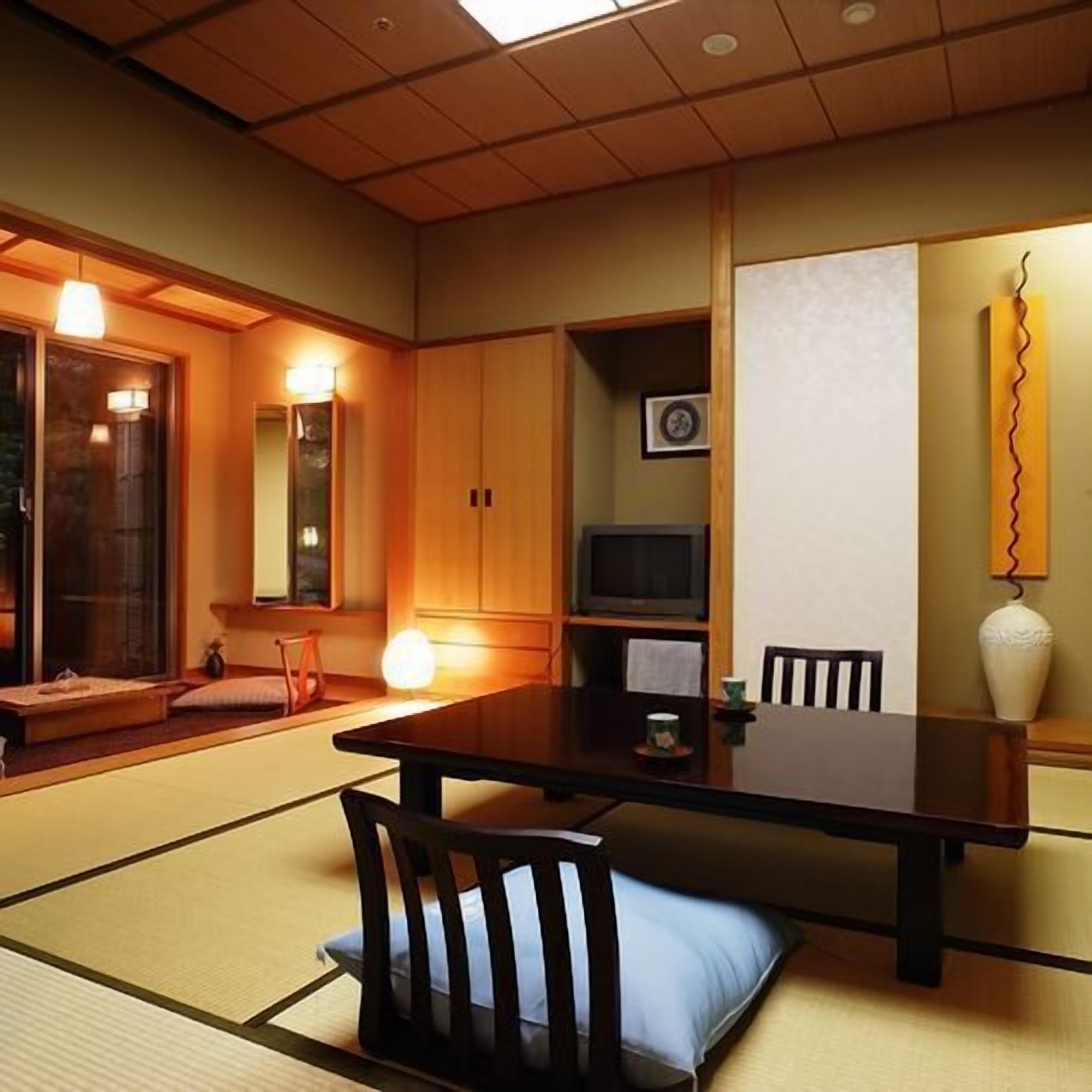 Une pièce de style japonais traditionnel, avec un sol recouvert de tatamis, une table basse et des chaises.