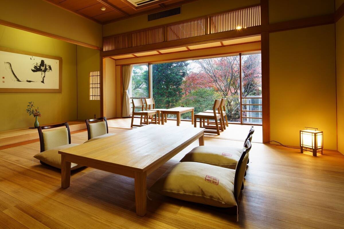 Ein traditioneller japanischer Raum mit Tatami-Böden, einem niedrigen Tisch und Stühlen.