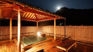 A wooden deck with a hot tub, a covered seating area, and a bamboo fence. - Niigata Iwamuro Onsen Jikagensen no Yado Fujiya (Niigata)
