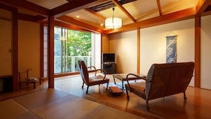 A traditional Japanese-style room with tatami flooring, a low table, and two chairs. - Niigata Iwamuro Onsen Jikagensen no Yado Fujiya (Niigata)