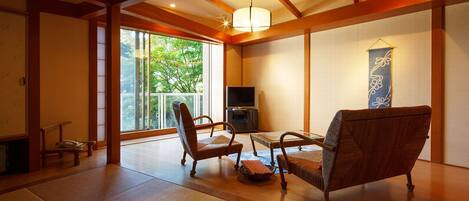 Una habitación de estilo japonés tradicional con suelo de tatami, una mesa baja y dos sillas.