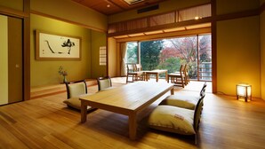 A traditional Japanese room with tatami flooring, a low table, and chairs. - Niigata Iwamuro Onsen Jikagensen no Yado Fujiya (Niigata)
