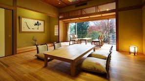 Una habitación japonesa tradicional con suelo de tatami, una mesa baja y sillas.