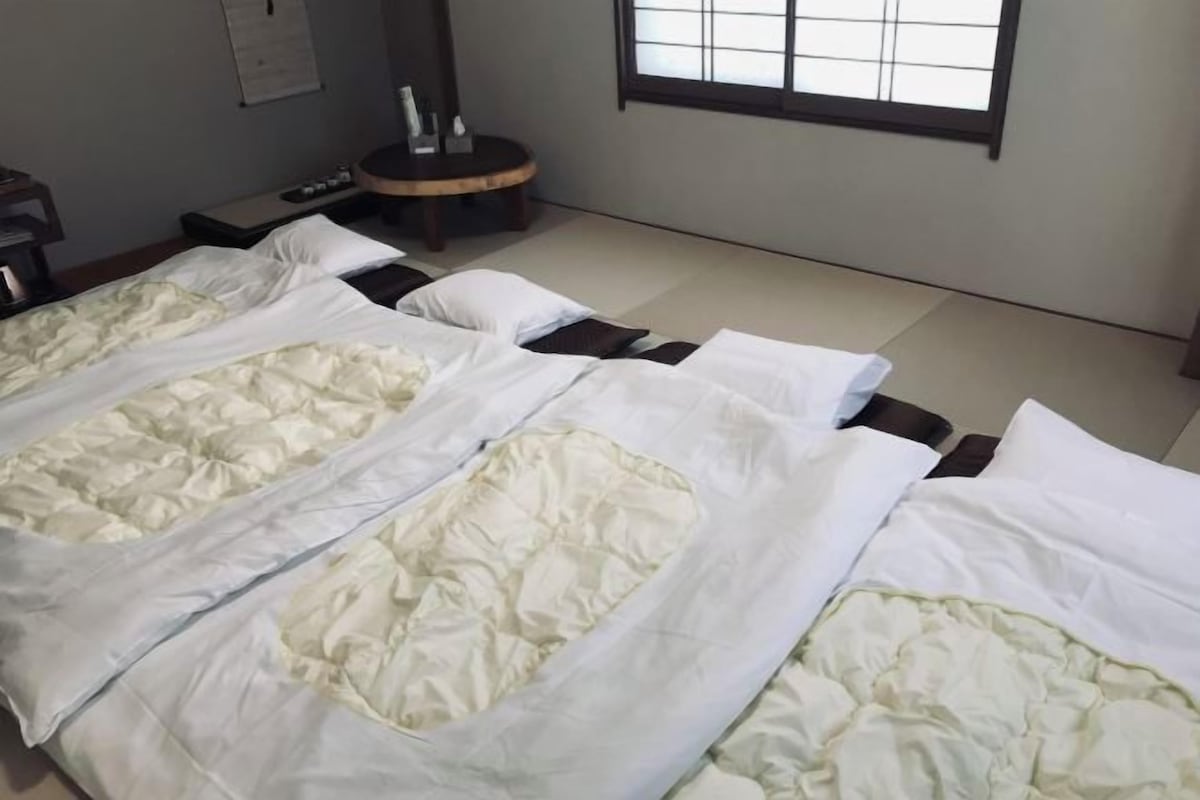 Une chambre d’hôtel avec un lit, une table ronde et une fenêtre.